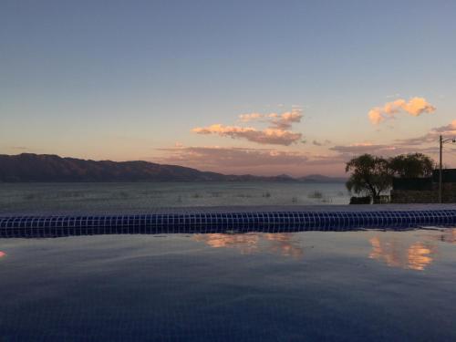 a swimming pool with a sunset in the background at Casa Bravía - Hotel·RV in San Luis Soyatlán