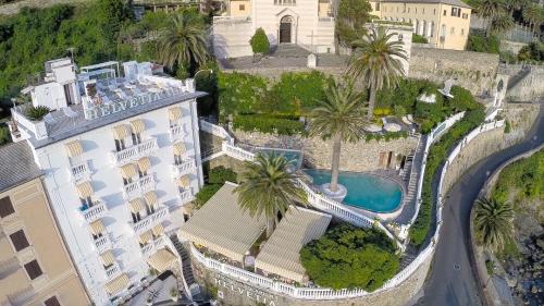 an aerial view of a building with a pool and palm trees at Hotel Helvetia in Sestri Levante