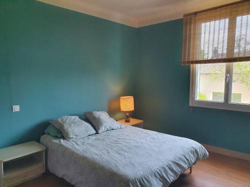 a bedroom with blue walls and a bed with a lamp at Big summer house in the charming village of Meyssac in Meyssac