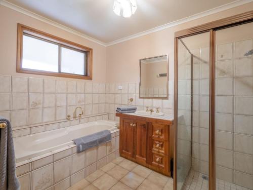 ein Bad mit einer Badewanne, einem Waschbecken und einer Dusche in der Unterkunft Eildon Motel Main house in Eildon
