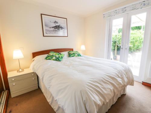 a bedroom with a large white bed with a window at Portland in Brodick
