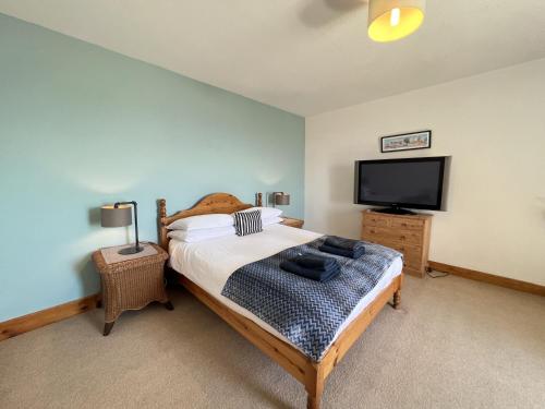 um quarto com uma cama e uma televisão de ecrã plano em Tall Ship - Three-bedroom coastal house with sea views em Anstruther