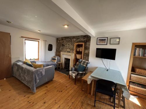 a living room with a couch and a tv at Tall Ship - Three-bedroom coastal house with sea views in Anstruther
