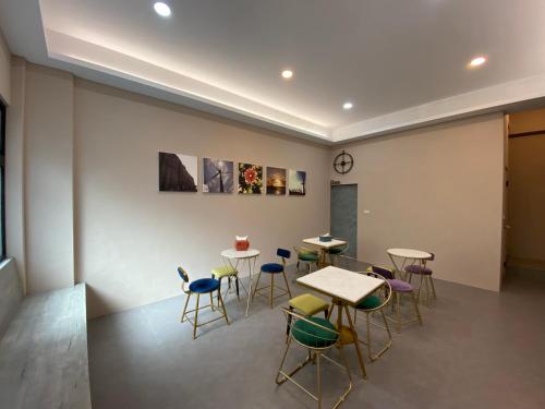 a room with tables and chairs and a wall at 珊號旅店 3inn in Magong