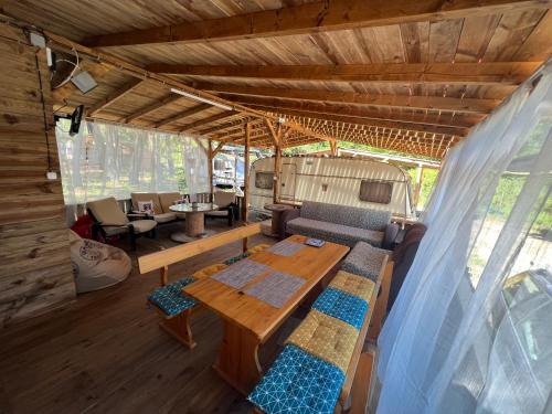 a living room with a wooden table and a couch at Каравана Чайка in Sozopol