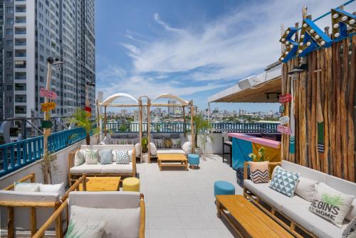 a patio with couches and tables on a balcony at Santori Hotel And Spa in Da Nang