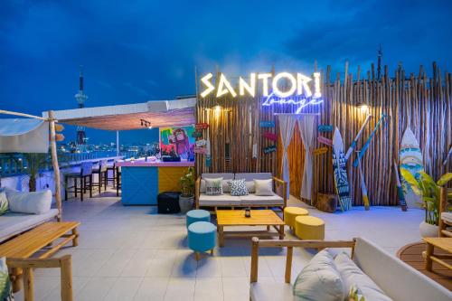 a patio with couches and tables and a bar at Santori Hotel And Spa in Da Nang