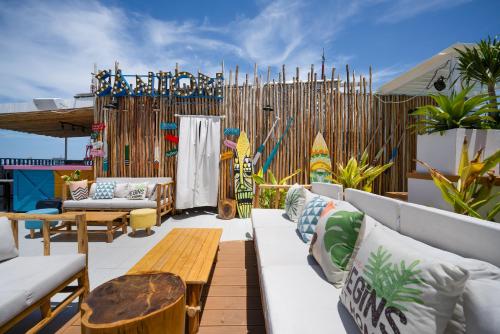 a patio with white couches and a wooden table at Santori Hotel And Spa in Da Nang