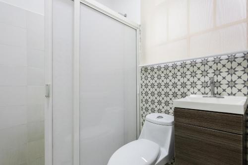a white bathroom with a toilet and a sink at Enjoy Condesa - Roma At Fully Equipped 2br Apartment Near Reforma in Mexico City
