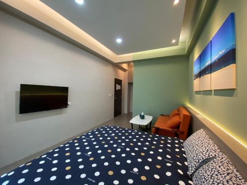 a bedroom with a bed and a tv on the wall at 珊號旅店 3inn in Magong