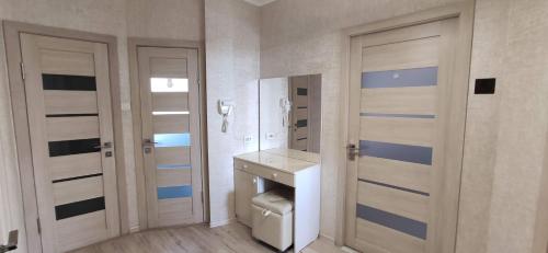 a bathroom with a toilet and a sink and two doors at Apartment in the Karakol heart in Karakol