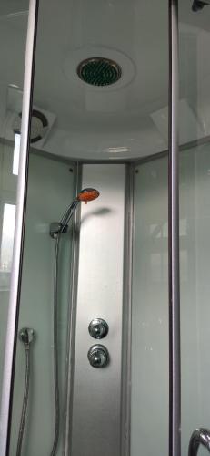a shower with a glass door and a shower coil at Apartment in the Karakol heart in Karakol