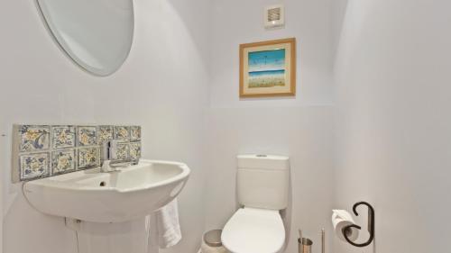 a white bathroom with a sink and a toilet at Razorback 6 in Mount Hotham