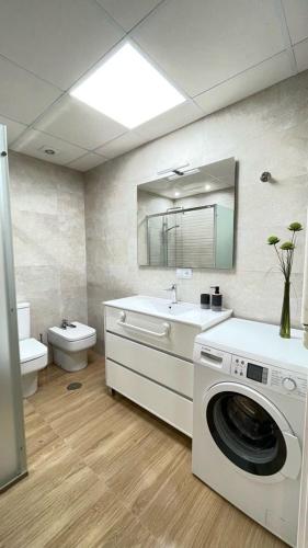a bathroom with a washing machine and a sink at Luxury apartment in central town in Sanlúcar de Barrameda