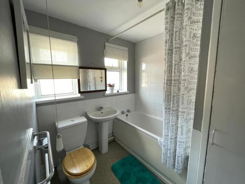 uma casa de banho com uma banheira, um WC e um lavatório. em Spacious 2 bed flat. em Whittington