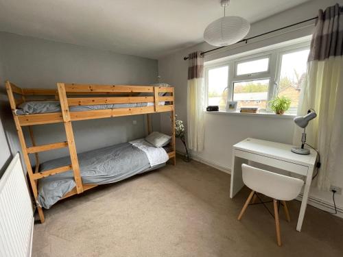 a bedroom with a bunk bed and a desk at Spacious 2 bed flat. in Whittington