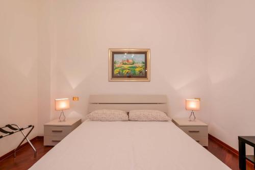 a bedroom with a large white bed with two lamps at Ai Marinai in Taranto