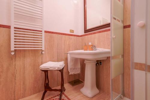 a bathroom with a sink and a mirror and a stool at Ai Marinai in Taranto