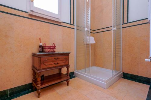 a bathroom with a shower and a wooden table with a drawer at Ai Marinai in Taranto