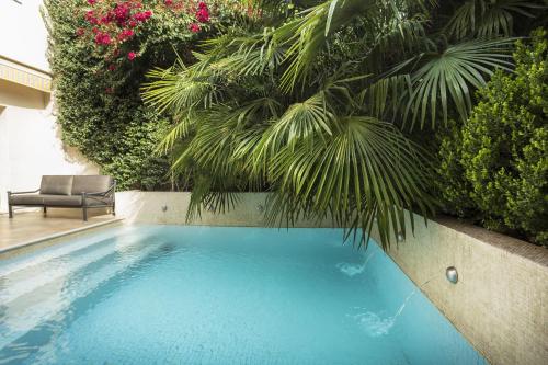 a swimming pool with a chair and some plants at Casa Sur - 400 m from the park at most elegant neighbourhood in Mendoza City in Mendoza