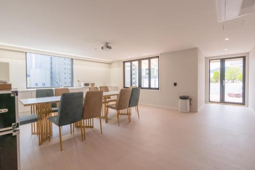 a dining room with a table and chairs and windows at Denbasta Central Hotel Seomyeon in Busan