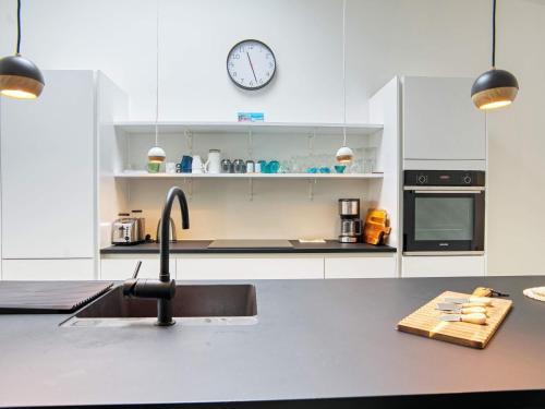 a kitchen with a sink and a clock on the wall at 6 person holiday home in Gilleleje-By Traum in Gilleleje