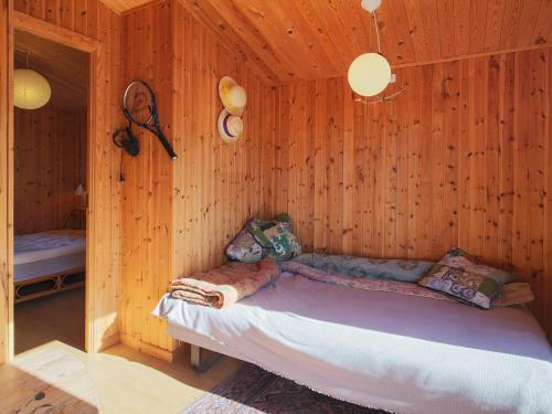 een slaapkamer met een bed in een houten kamer bij Holiday home Gilleleje LXXXVII in Gilleleje