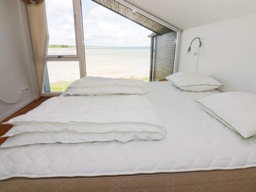 um quarto com uma grande cama branca e uma grande janela em Holiday home Hadsund CXXXI em Hadsund