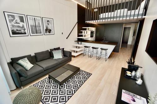 ein Wohnzimmer mit einem Sofa und einer Küche in der Unterkunft Chalet Park by Maier Mäder in Mäder