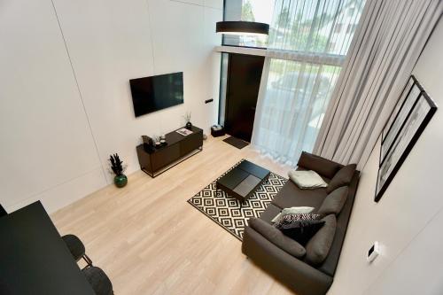 a living room with a couch and a television at Chalet Park by Maier Mäder in Mäder