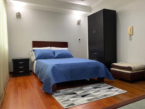 フサガスガにあるHermoso apartamento, excelente ubicación, WI FIの青い掛け布団が敷かれたベッドのある寝室