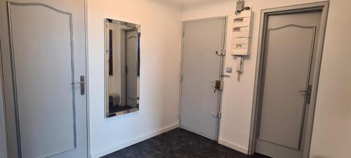 a room with two doors and a mirror on the wall at Appartement 65m² Paris - DisneyLand - RER A in Noisy-le-Grand