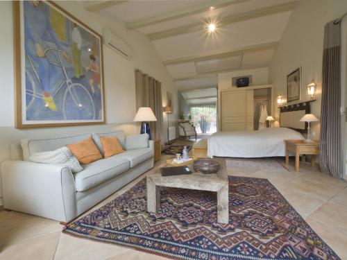 uma sala de estar com um sofá e uma cama em La Bégude Du Pascouren em Fayence