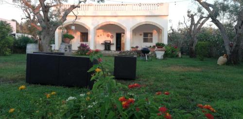 切薩雷奧港的住宿－Casa NonnoNanni，前面有鲜花的院子的房子