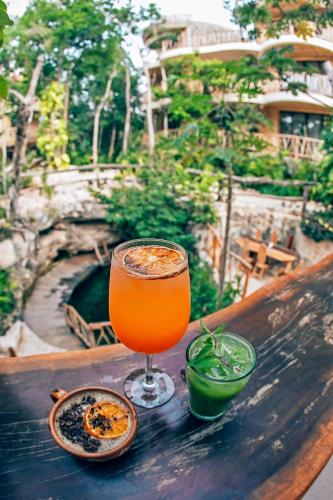 a glass of orange juice sitting on top of a table at Kan Tulum Hotel in Tulum
