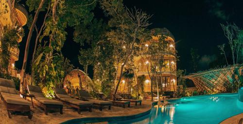 a resort with a swimming pool at night at Kan Tulum Hotel in Tulum