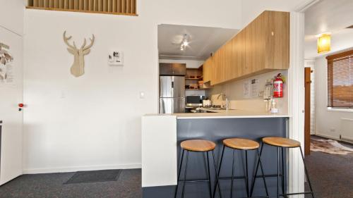 a kitchen with two stools at a counter at Shamrock 3 in Mount Hotham