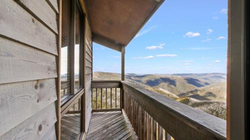 a room with a balcony with a view of the mountains at Shamrock 3 in Mount Hotham