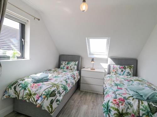 1 Schlafzimmer mit 2 Betten und einem Fenster in der Unterkunft The Cottage 
