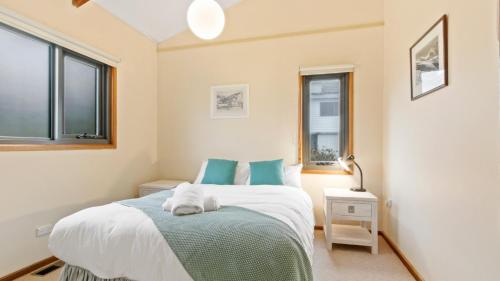 a bedroom with a bed and two windows at Snowtel 1 in Mount Hotham