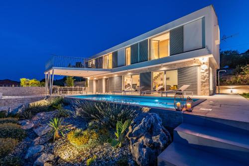 a house with a swimming pool in front of it at Villa Mezano in Žman