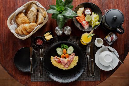 ウブドにあるBubu Mesari Ubud Villaの木製テーブル(食べ物、ペストリー付)