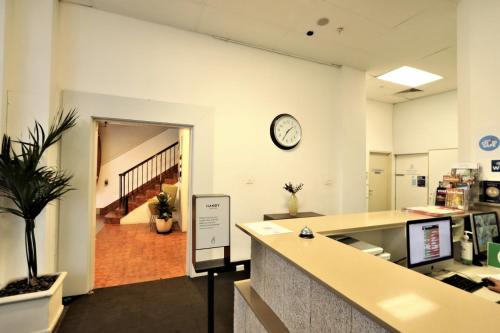 un bureau avec un bureau et une horloge sur le mur dans l'établissement Siesta Sydney, à Sydney