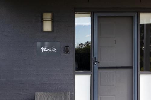 a door to a building with a sign on it at The Grange On Hermitage in Pokolbin