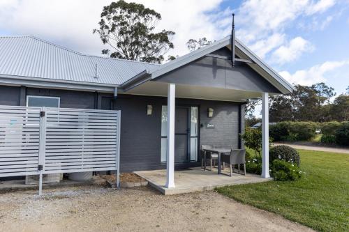 a house with a porch with a table in it at The Grange On Hermitage in Pokolbin