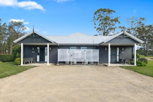 a grey house with a driveway in front of it at The Grange On Hermitage in Pokolbin