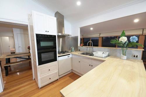 a kitchen with white cabinets and a vase of flowers at Vermont 8 Bdrm Holiday Entire House for Big Group in Vermont