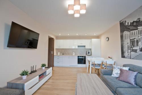 a living room with a blue couch and a table at Academy Apartment Cieszyn in Cieszyn