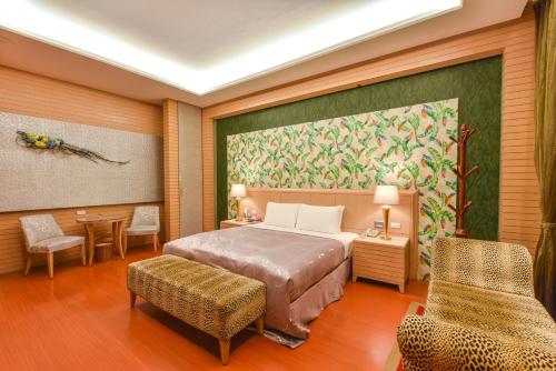 a bedroom with a bed and a painting on the wall at Purple Garden Motel in Kaohsiung