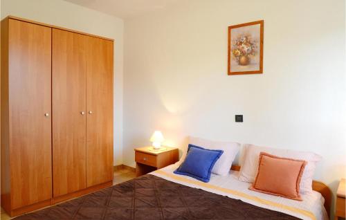 a bedroom with a bed and a wooden cabinet at Beautiful Home In Rabac With Wifi in Rabac